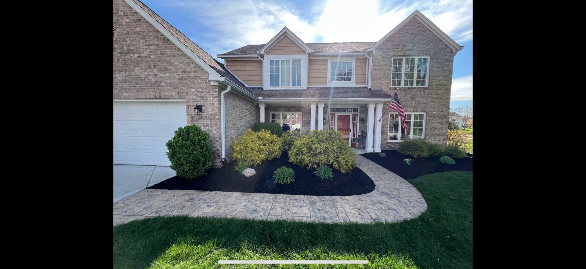 Front Yard Landscape Redesign with New Shrubs and Black Mulch image